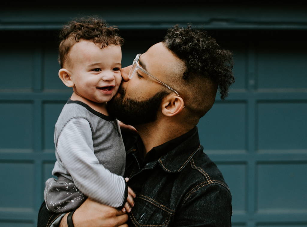 Father kissing his son in the cheek.