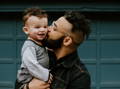 Father kissing his son in the cheek. 