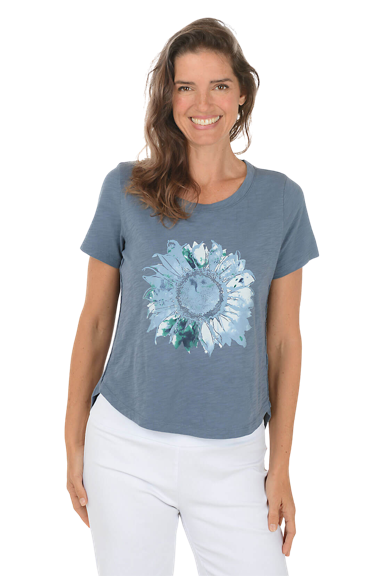A woman wears a blue denim sunflower cotton graphic tee.