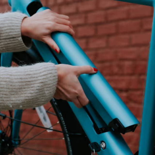 Rider removing battery of Tenway electric bike
