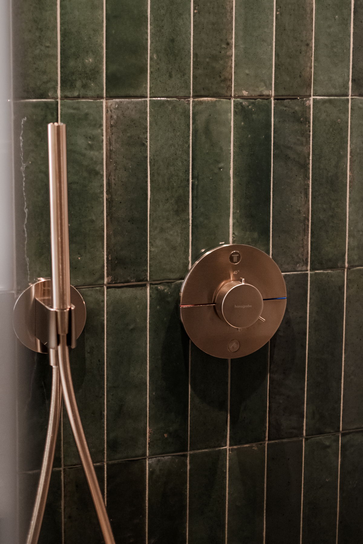 Moderne Dusche mit dunklen Fliesen im Apartment Waldgeflüster von Hugo & Pepi.