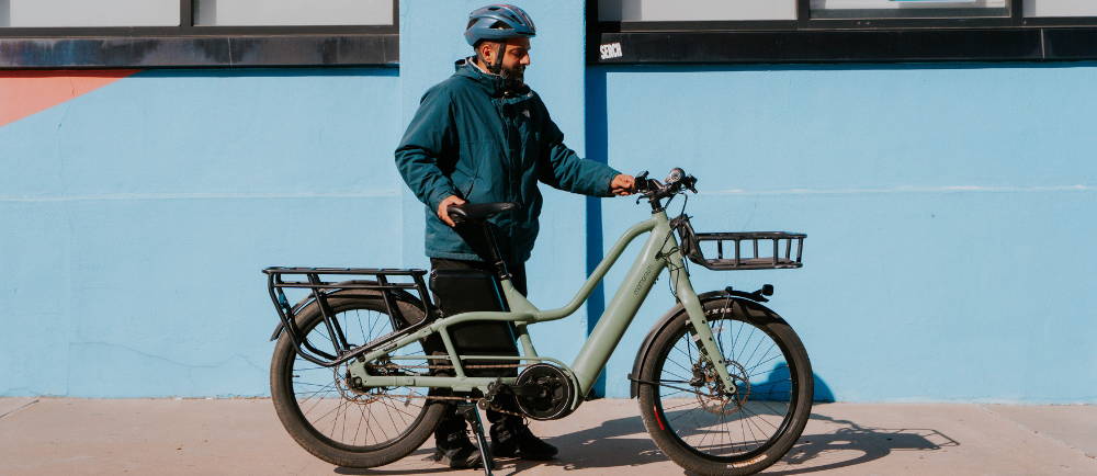 a man standing next to a Momentum PakYak E+ electric cargo bike
