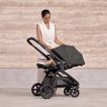 Lifestyle photo of a parent using the Redsbaby ONIX pram outdoors.