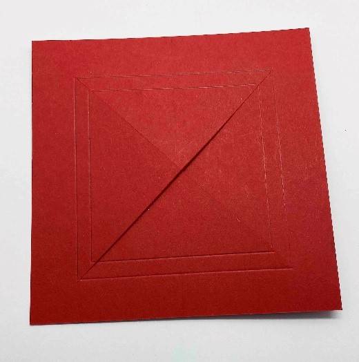 Det store røde kort er skåret diagonalt fra hjørne til hjørne for at lave fire trekanter inden for scorelinjerne