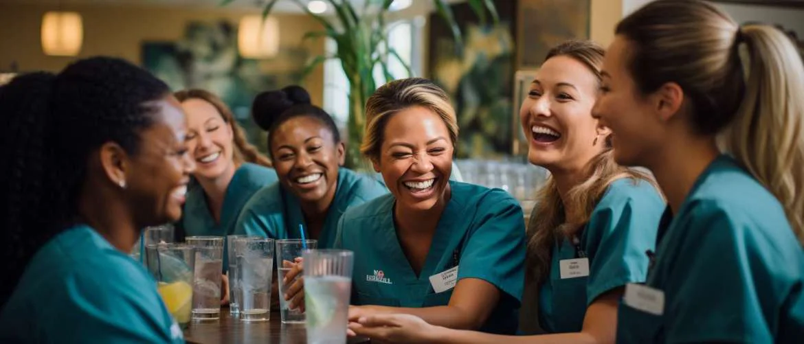 Nurses sharing stories and laughter in a cozy break room.