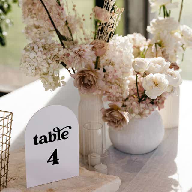 Retro arch table number template with stylish font. Displayed on a wedding table setting in dusty rose tones for a vintage touch