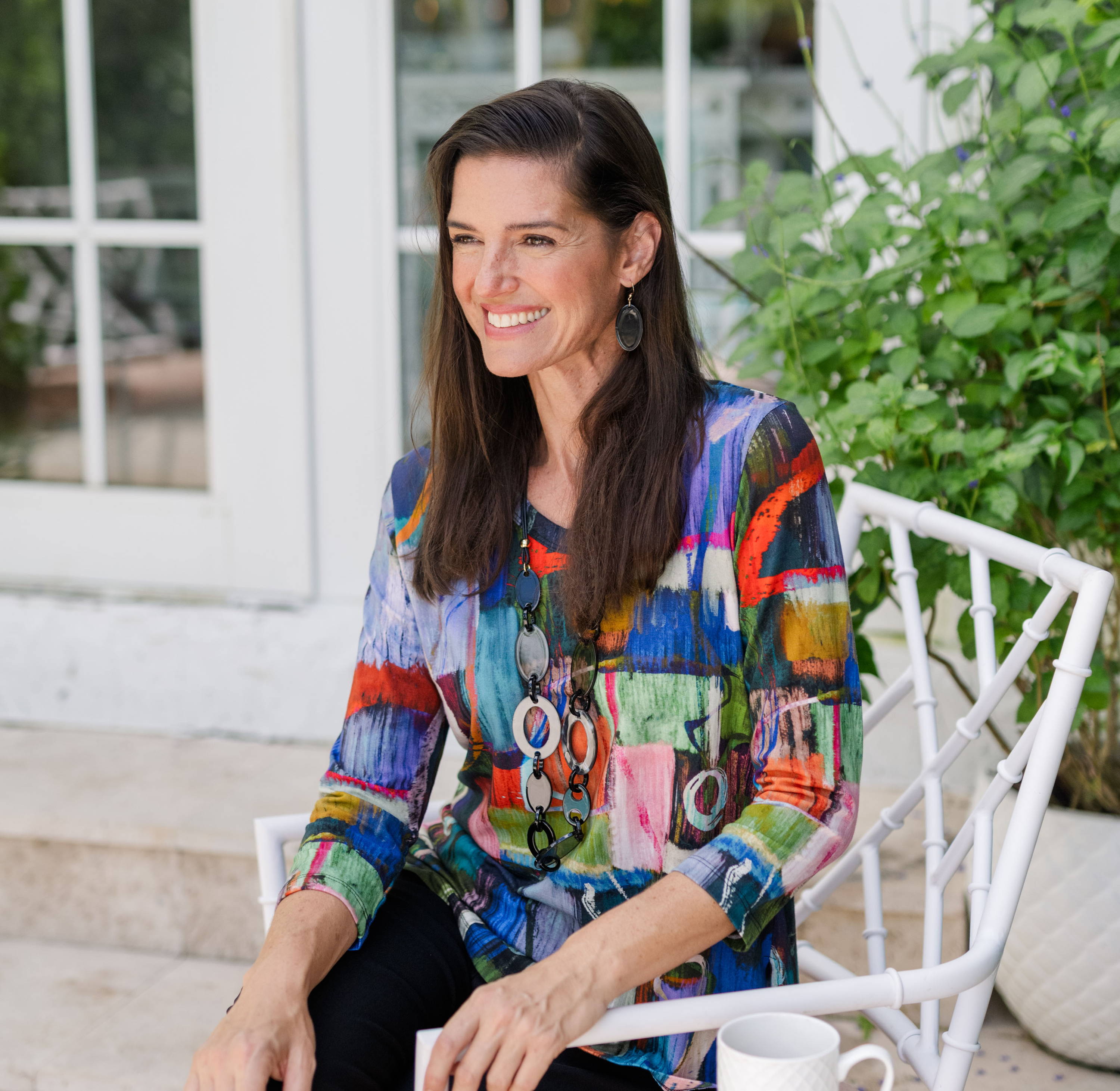 A woman wears a barcelona cotton-blend v-neck top and black pull-on ankle pants while she relaxes outside.