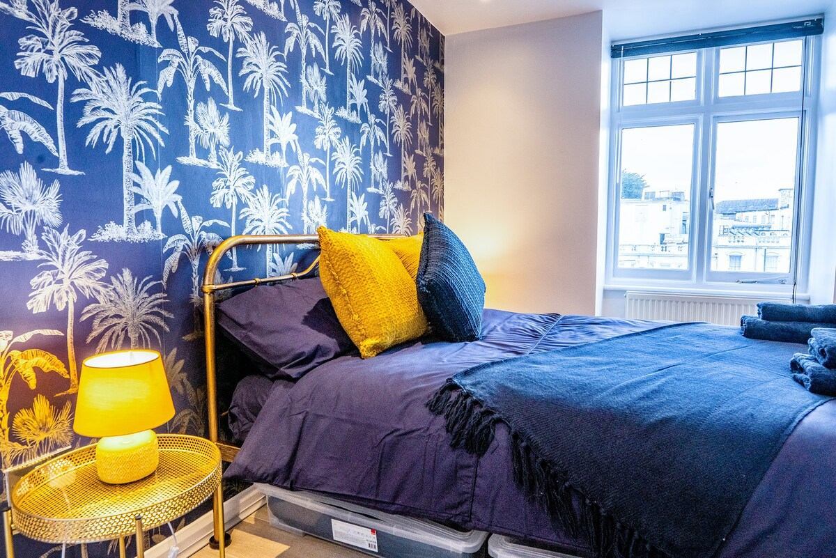 Bedroom with blue bed sheets and yellow pillows