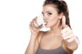 Girl drinking from a glass and giving a thumbs up - quality collagen supplements are tasteless and mix well with anything!