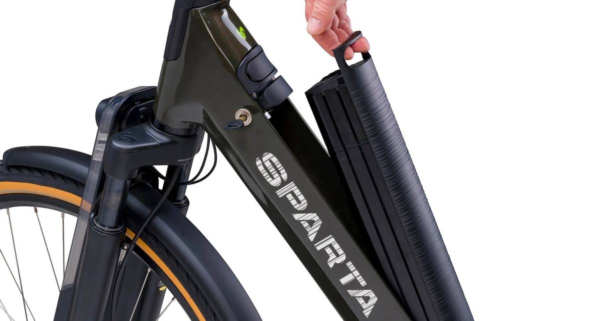 Main qui retire la batterie intégrée du cadre d'un vélo électrique Sparta pour la réinitialiser
