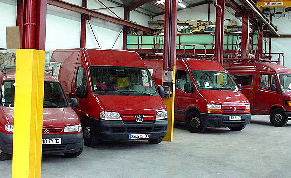 Camionnettes rouges de l’entreprise Rossio garées dans l’atelier de Montreuil