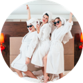 photo of 3 women in bathrobes holding champagne glasses and celebrating their friendship
