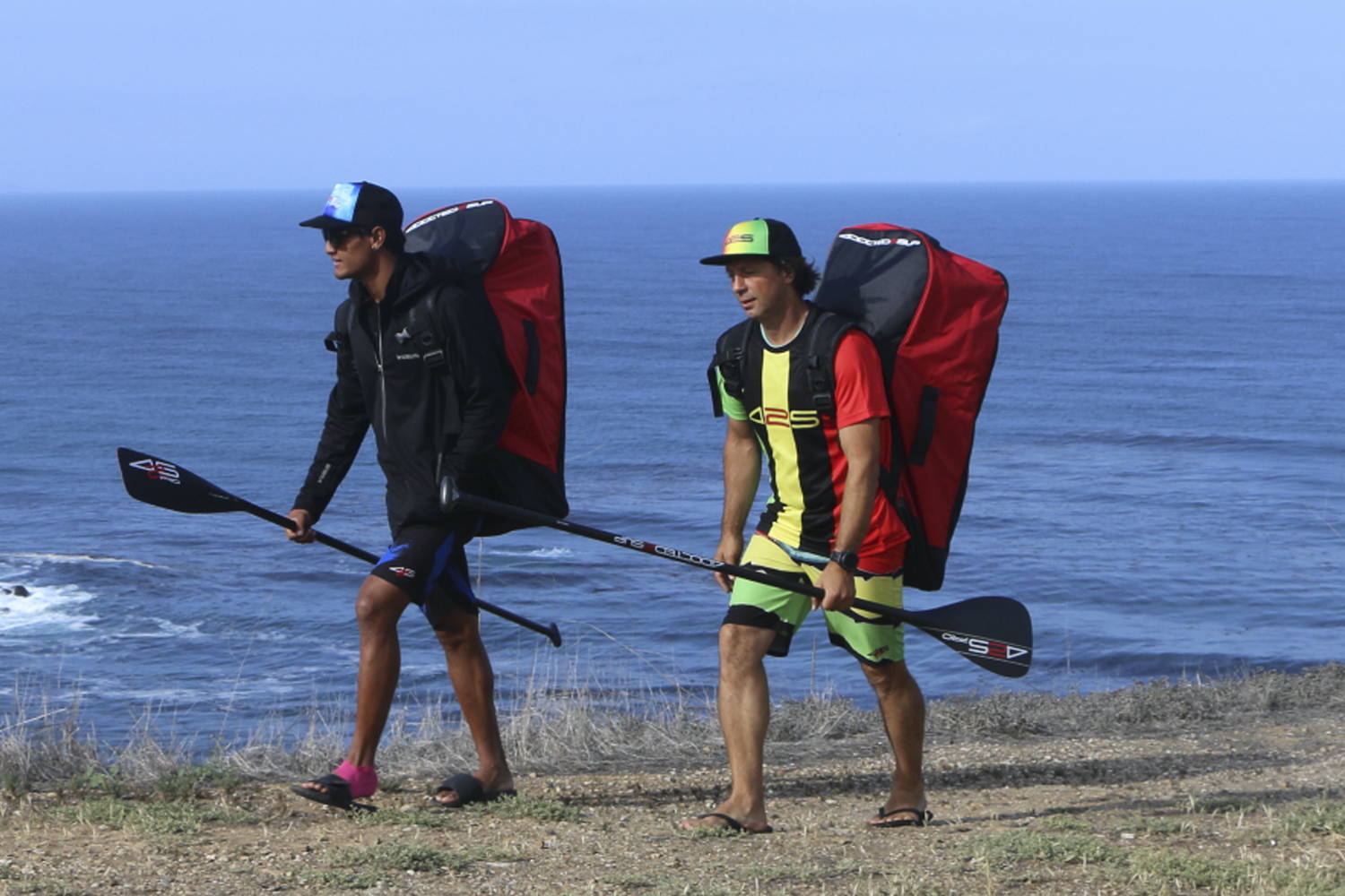 425pro paddles: Two men carrying the paddles on the sea coast