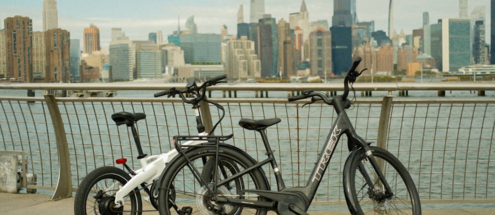 two electric bikes near the hudson river with new york city in the distance