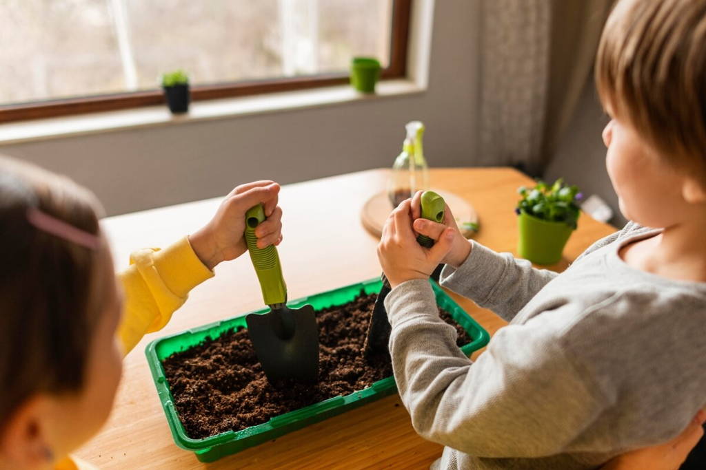 Siblings making a small garden in their playroom.