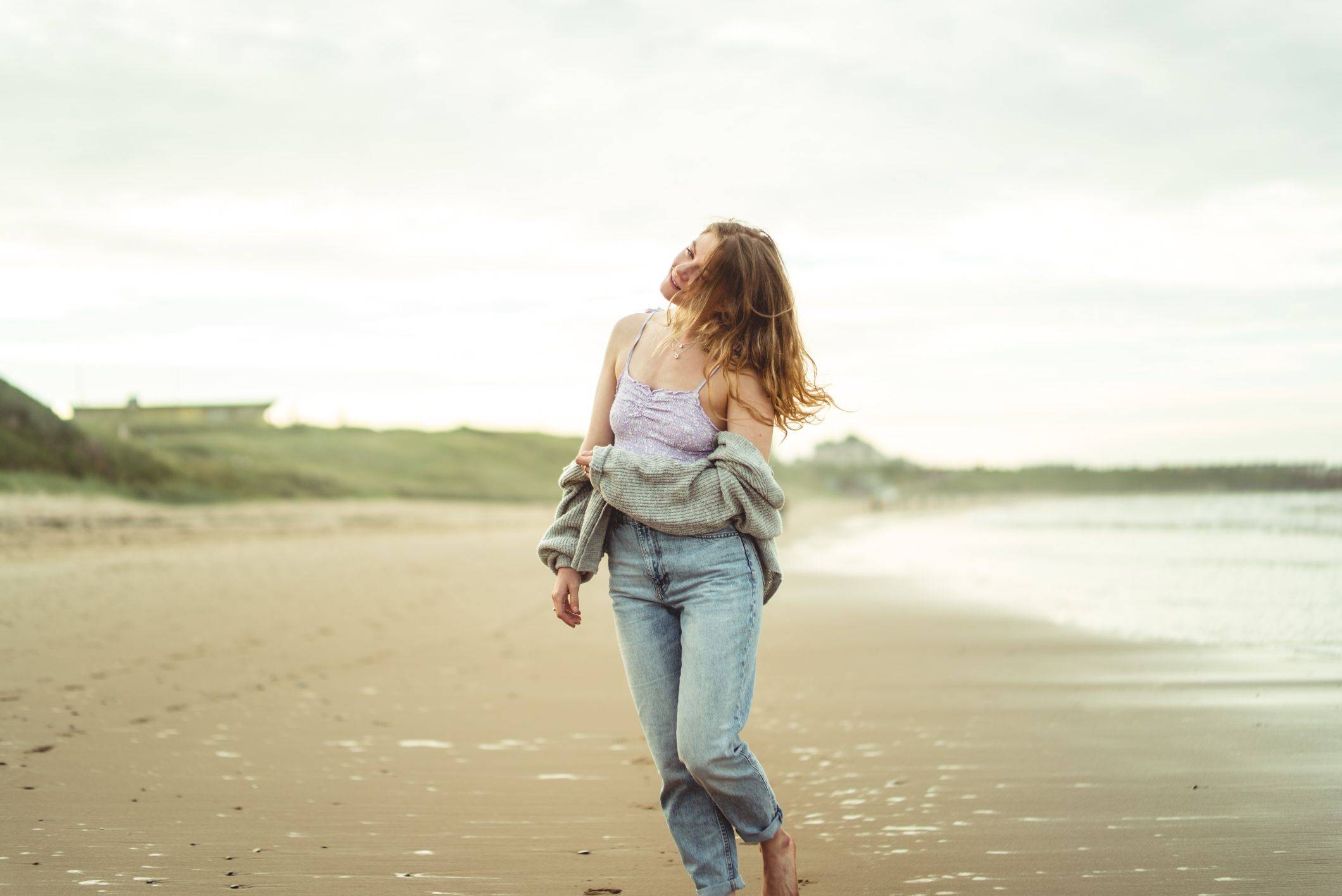 girl walking on beach with wavy hair