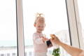 Child misting her hand with water during a summer themed sensory play activity.