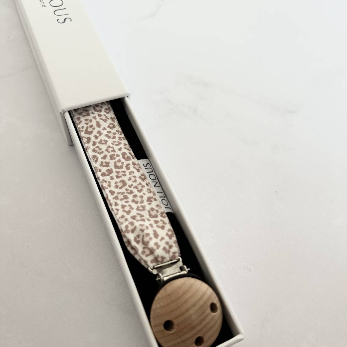 Attache-tétine élégant de la marque suisse 'Joli Nous', un accessoire premium pour bébé, alliant design raffiné et qualité exceptionnelle OEKO-TEX fabriqué portugal