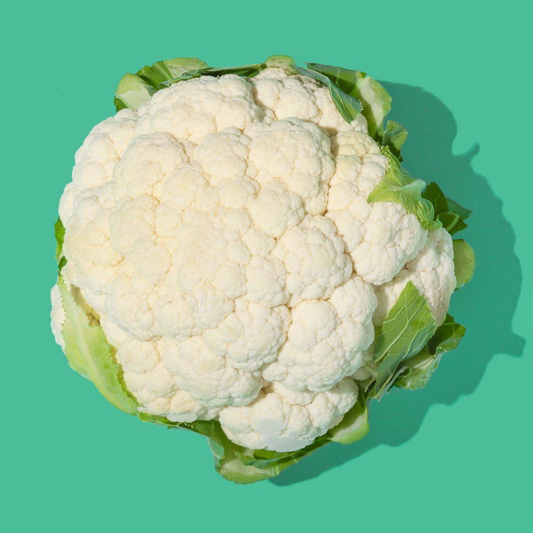 head of cauliflower on green background