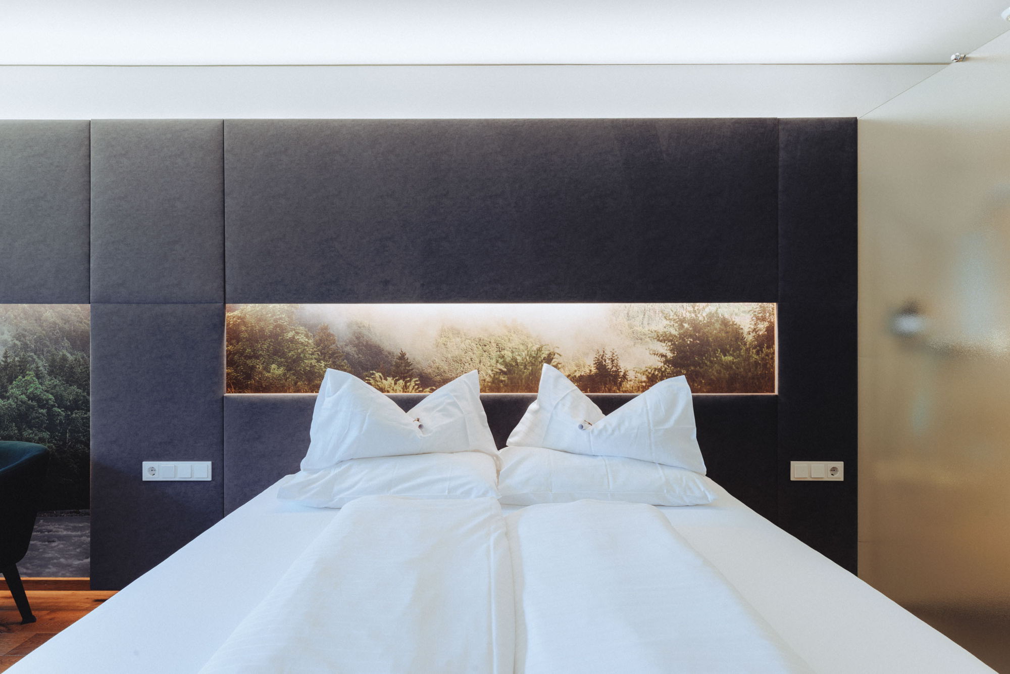 Doppelbett im Zimmer Hangspitze der Sonne Mellau mit dunkler Wandgestaltung