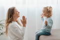 Parent and toddler playing clap-the-pattern listening game together at home.