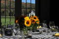 white and black checkered tablecloth on a table with sunflowers in the center and lots of glassware