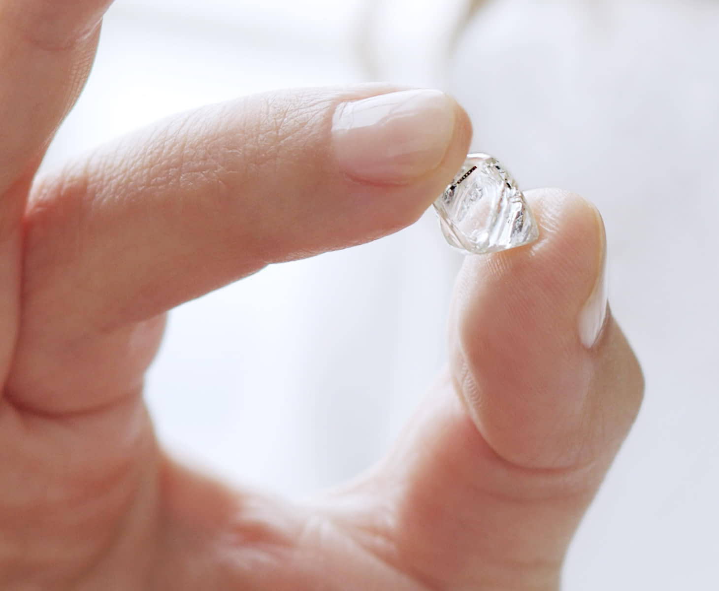 A person holding an uncut diamond.