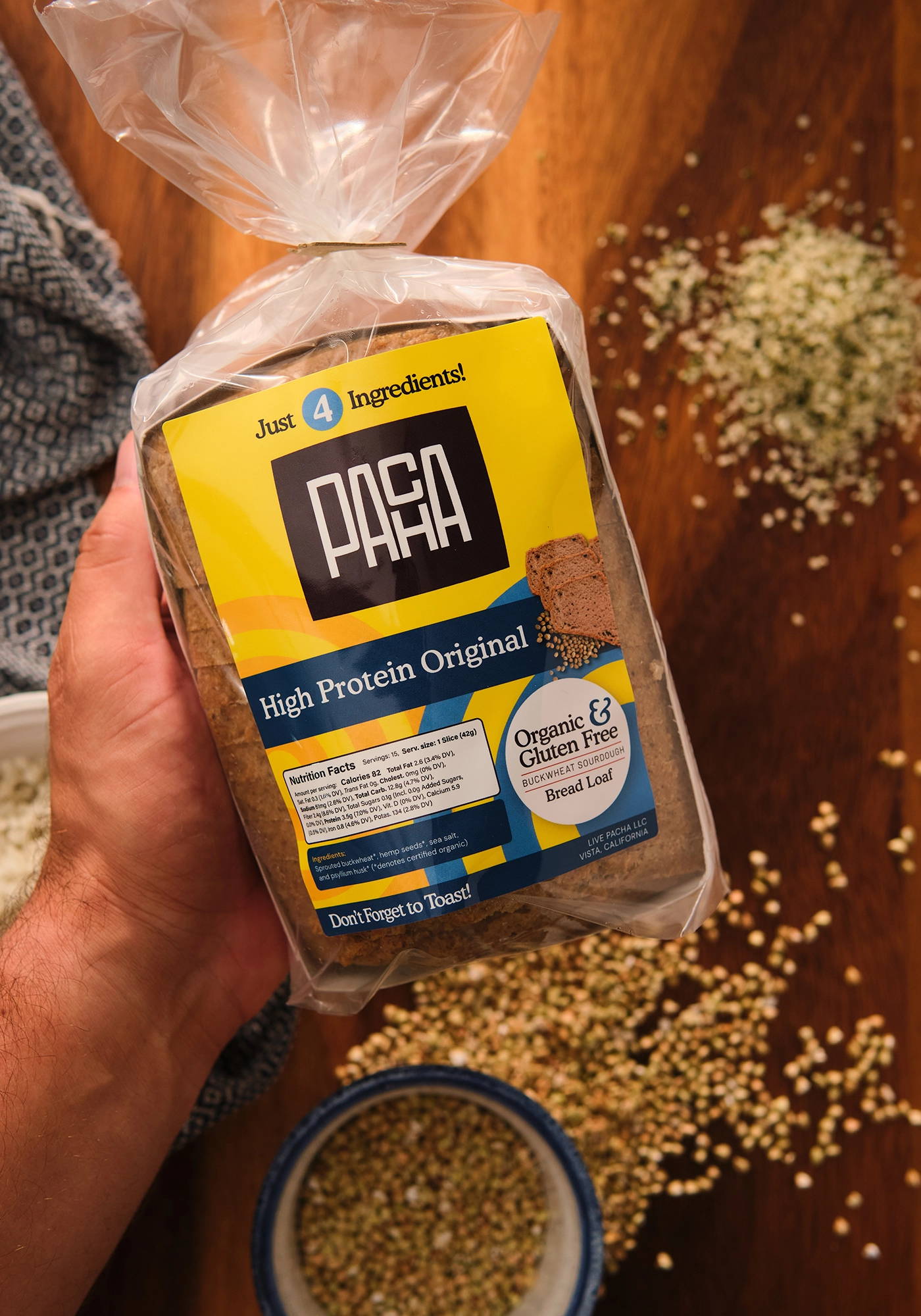 Close-up of a hand holding the packaged PACHA Limited Edition High Protein Hemp Loaf.