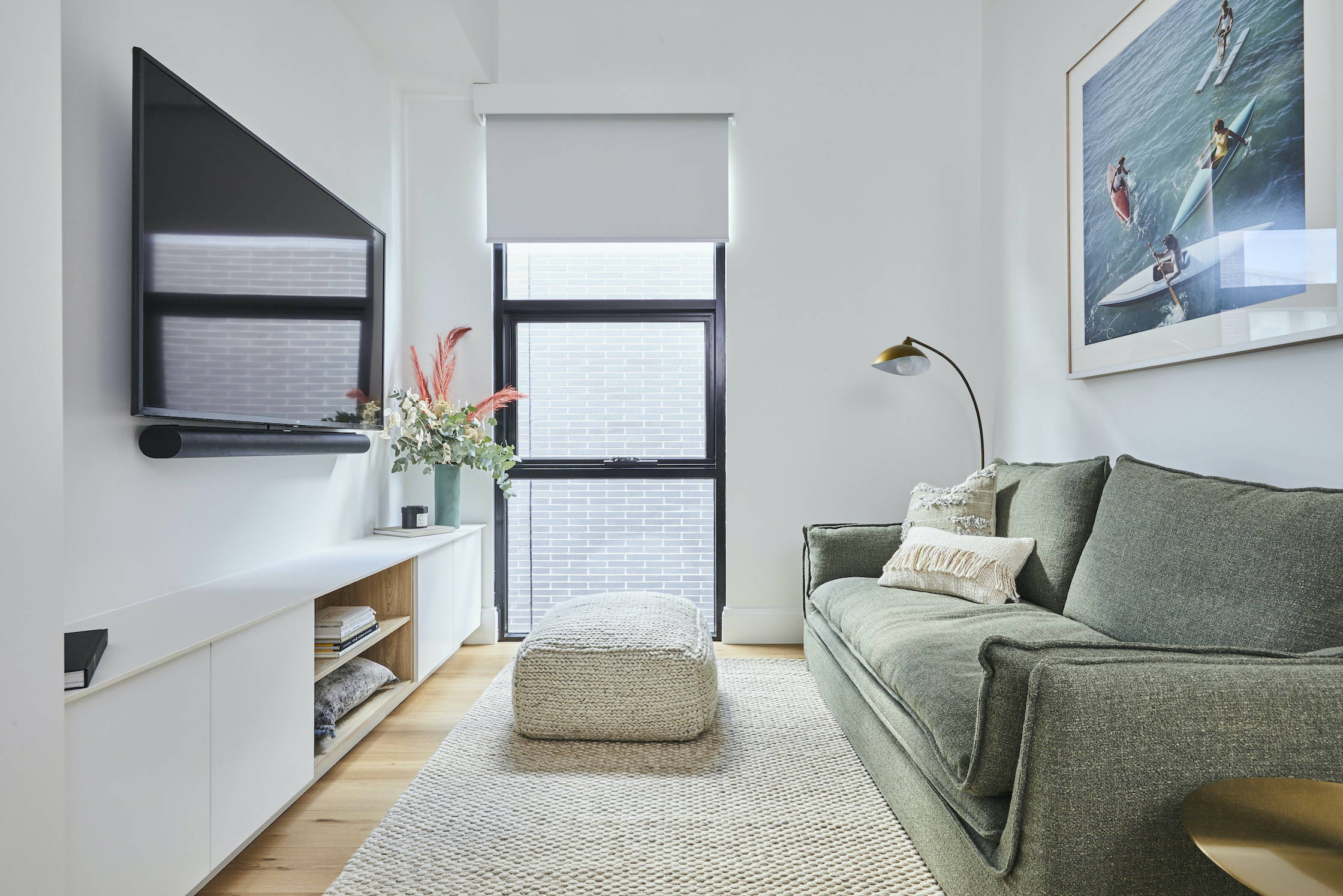 A TV-Mirror hanging on the wall of a coastal, elegant bedroom setting 