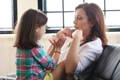 Daughter sitting in her mother's lap.