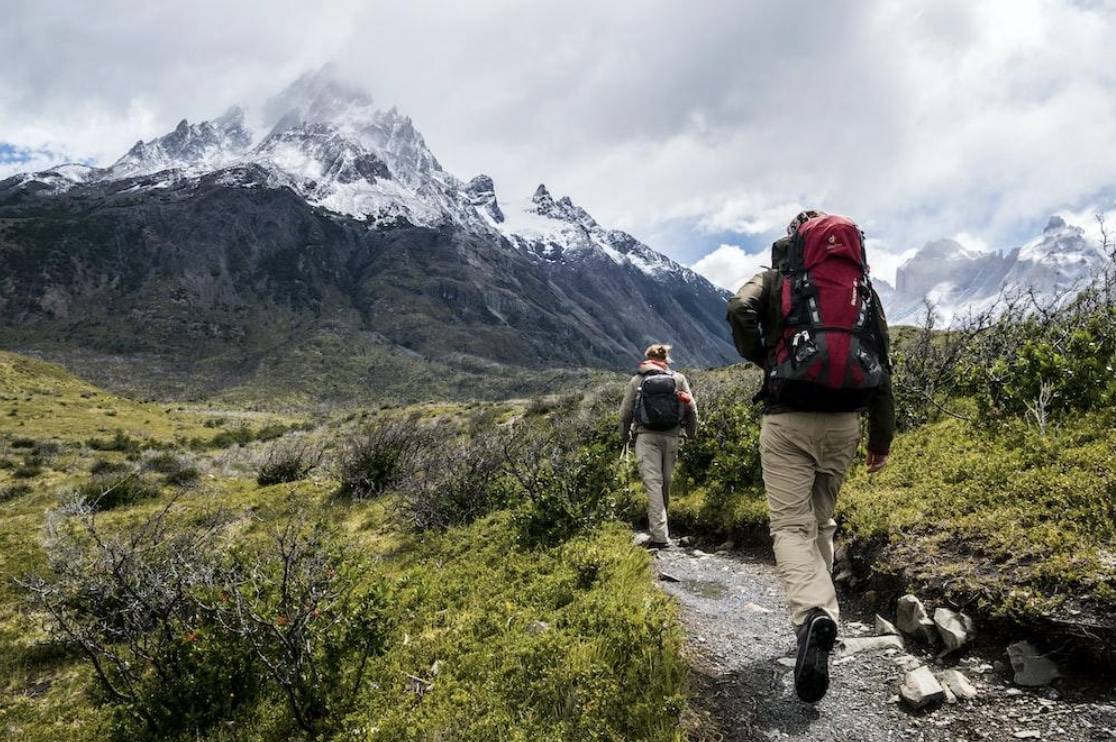  two people hiking on a mountain trail 