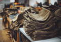 a stack of waxed canvas packs sitting on a table on the production floor