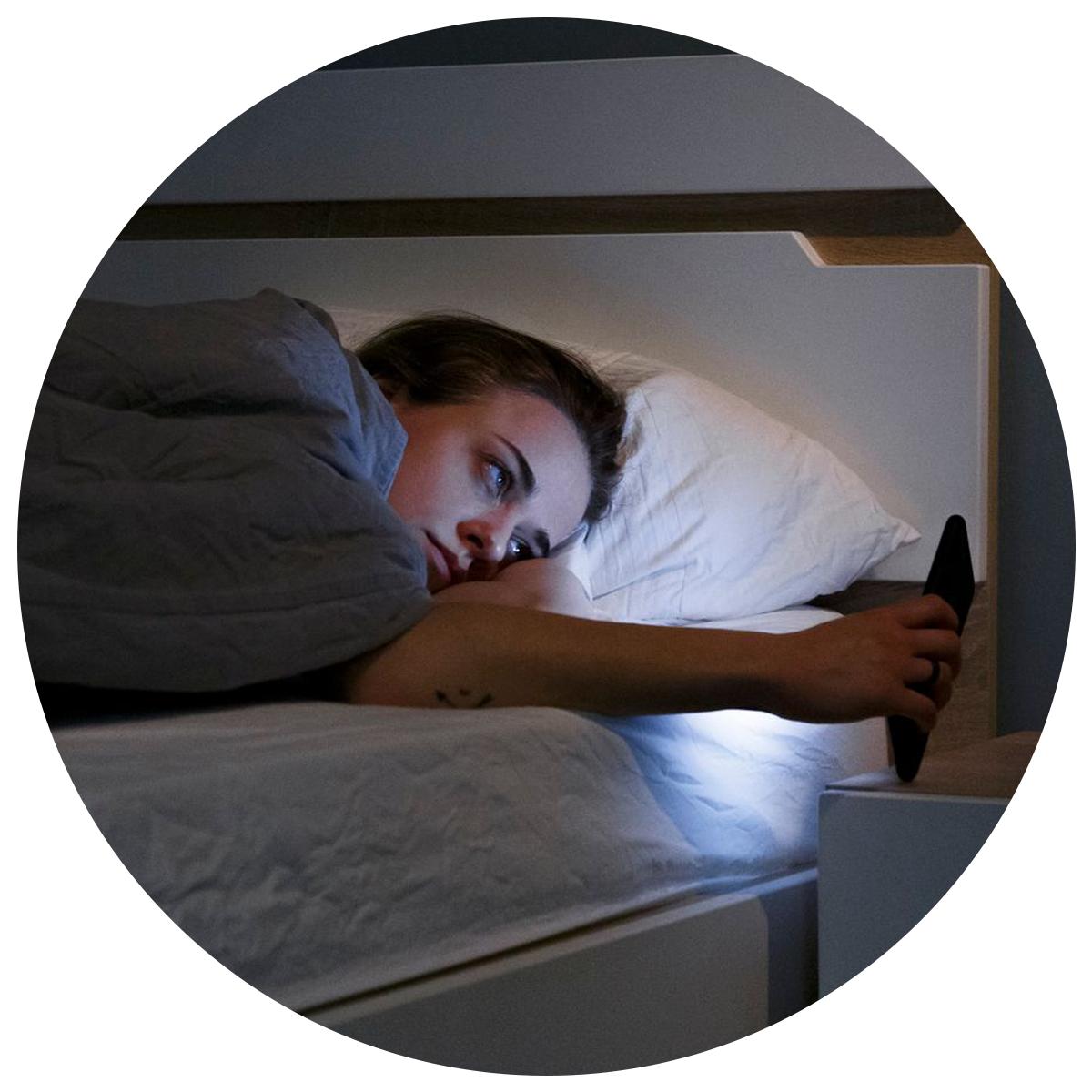 A person on the phone showing lack of sleep that can be avoided by taking elderberry gummies benefits
