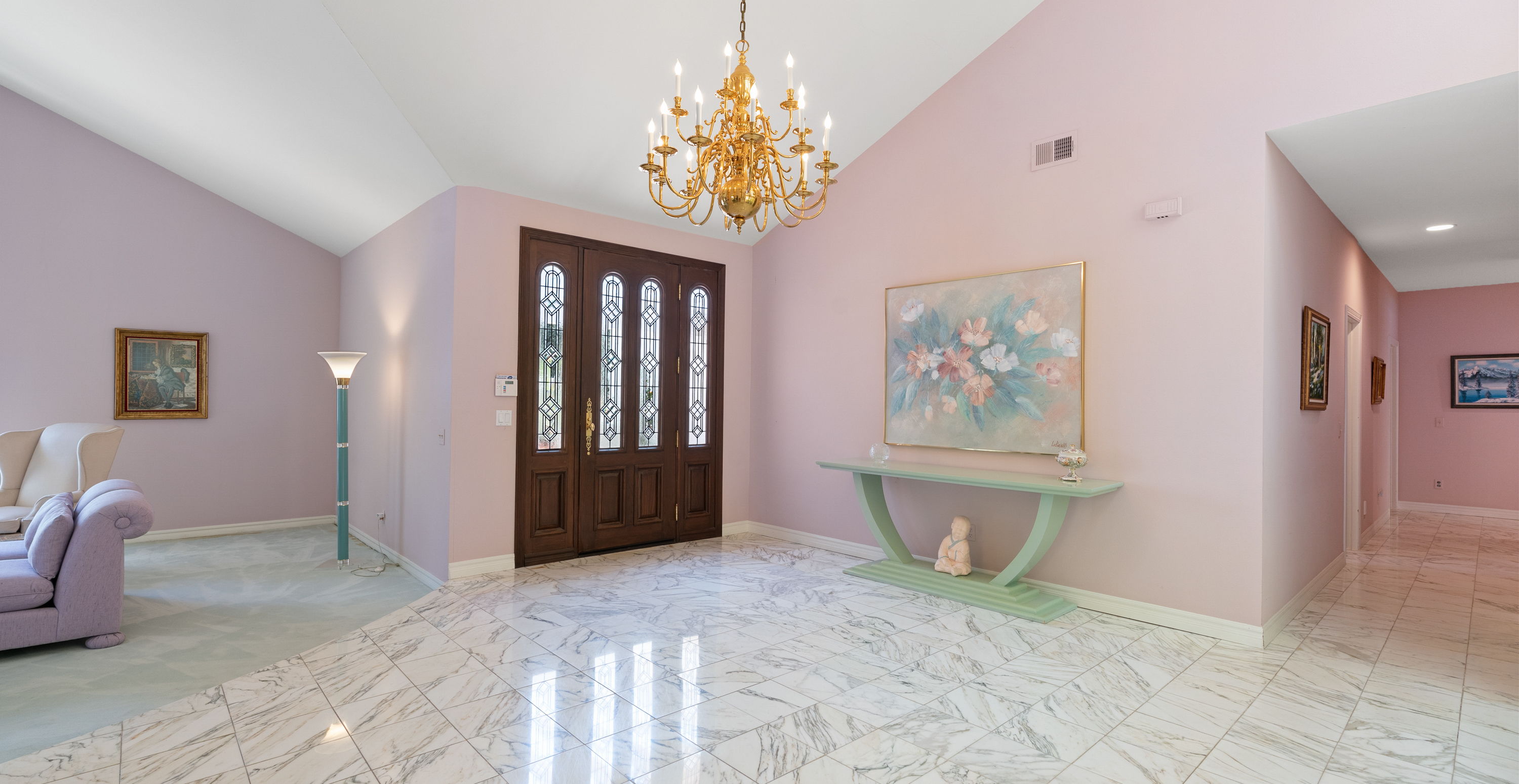 entryway with vaulted ceiling, tile floors, and a notable chandelier
