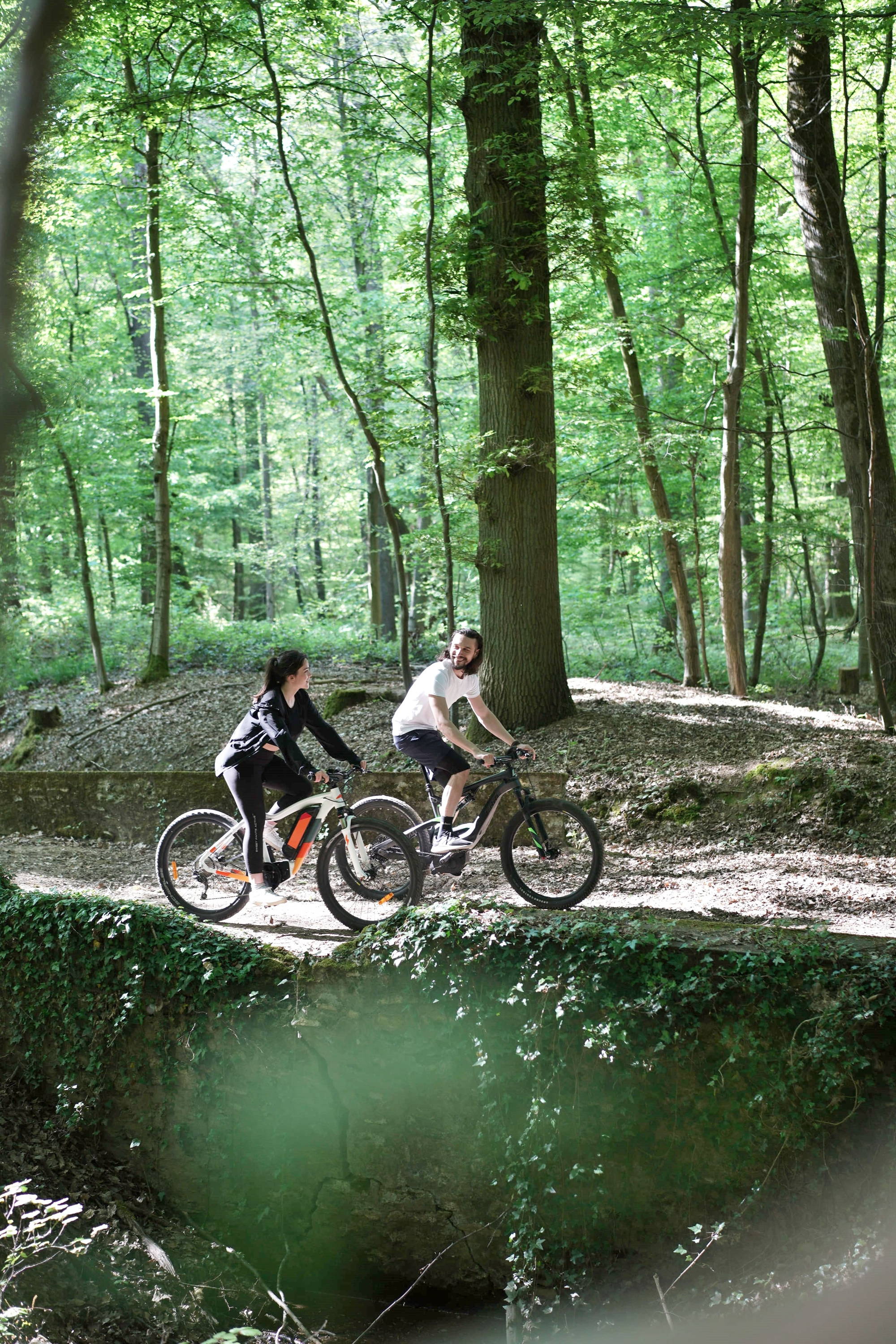 Paar op elektrische fietsen tijdens een boswandeling