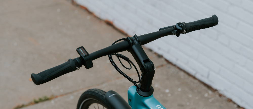 A teal Tenways electric commuter bike's handlebars