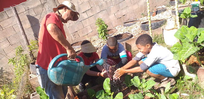 criancas regando plantas na horta do projeto itamar