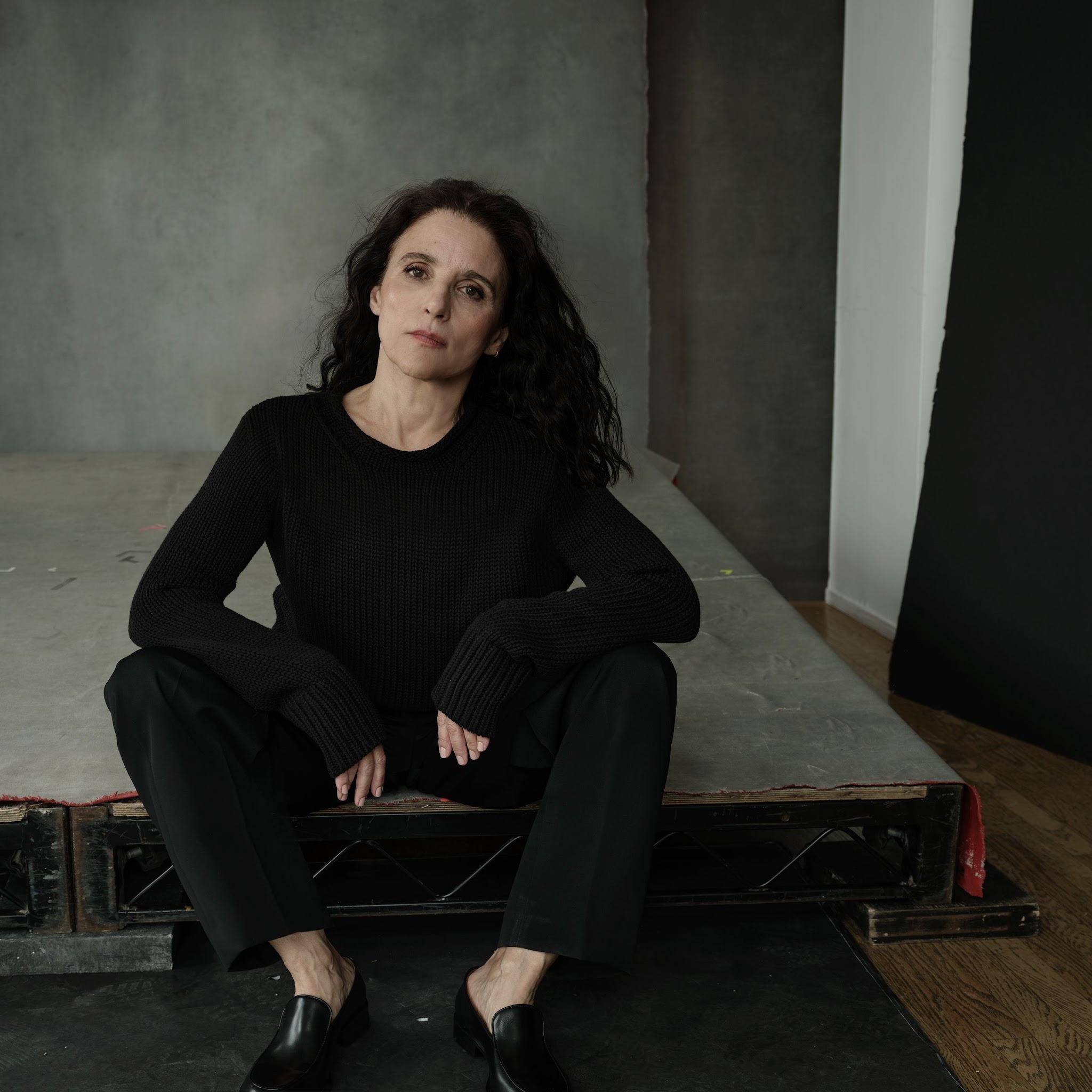 Julia Louis-Dreyfus sitting down.