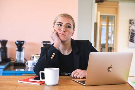 Business woman looking tired in front of her laptop