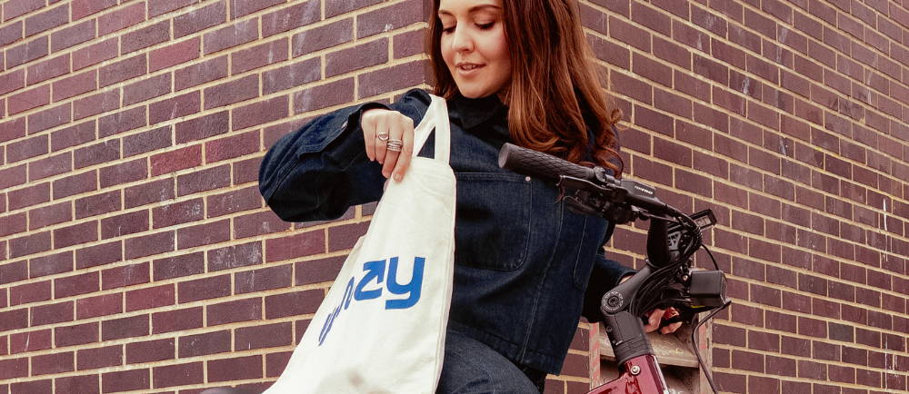 Female sitting on an ebike looking in her Upway bag