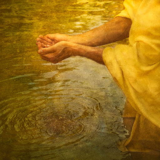 Jesus cupping clear river water in HIs hands.