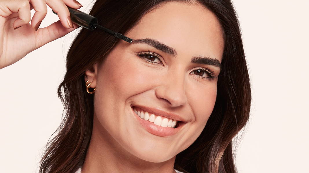 Femme souriante applicant du maquillage à sourcils Bourjois