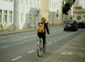 Femme à vélo se déplace en ville, vue du dos
