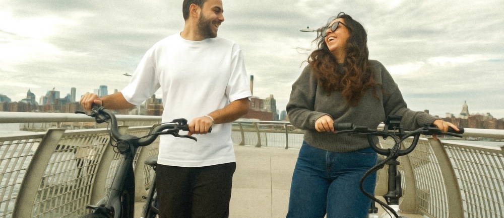 couple pushing their ebikes over a bridge in NY