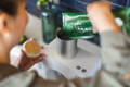 a woman pouring fresh matcha leaves into a Cuzen Matcha Maker.