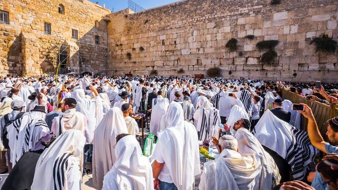 JERUSALEM, ISRAEL - SEPTEMBER 26, 2018 Thousands of Jews, wrapped in tallits, pray at the Western Wall. Morning autumn Sukkot. The Jews hold four ritual plants. Blessing of the Kohanim
