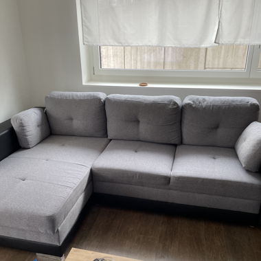 Graue, ausziehbare Couch mit 2 separaten Hockern