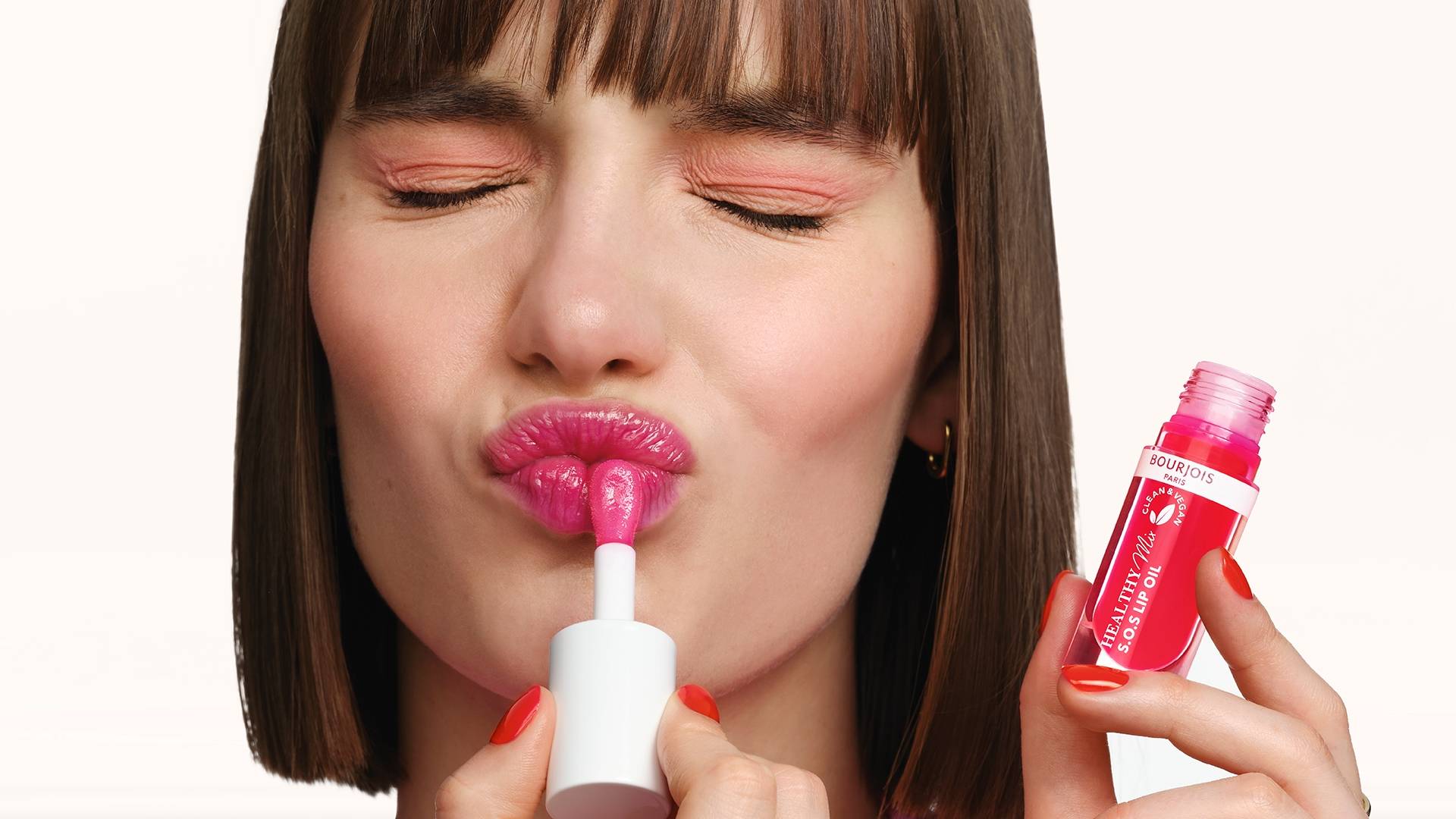Femme qui applique un rouge à lèvres rose Brillant Bourjois