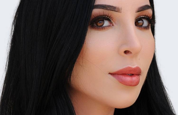 Headshot of beautiful woman with long dark hair and cute nose