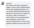 Hund sitzt auf der Wiese und hechelt in die Kamera